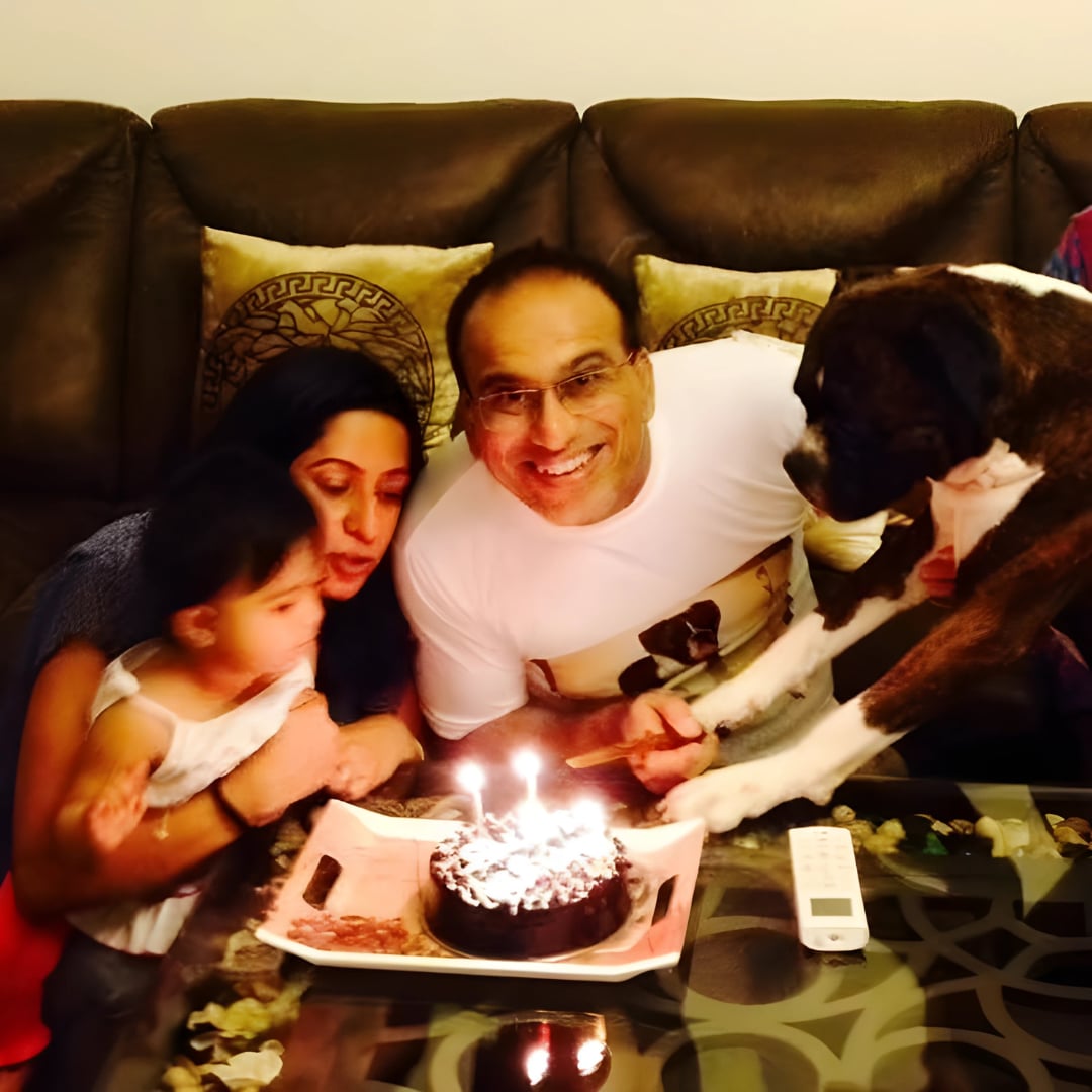 The family celebrating with Brutus reaching for the birthday cake